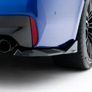 Close-up of a blue car's rear corner with dual exhausts and a red tail light.