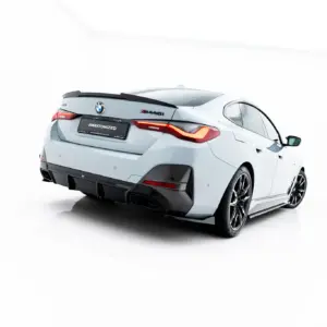 Rear three-quarter view of a white BMW M4 with red taillights and carbon rear diffuser, #MAKTONIZED plate visible