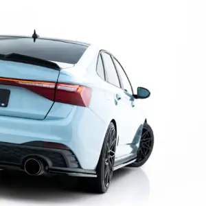Rear three-quarter view of a light-blue VW GLI with a red taillight bar and sporty rear bumper on a white background