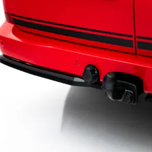 Close-up of a red car bumper showing a black tow hitch and trim lines along the side panel
