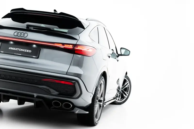 Rear three-quarter view of a white Audi SUV with a black rear spoiler and red LED taillights.