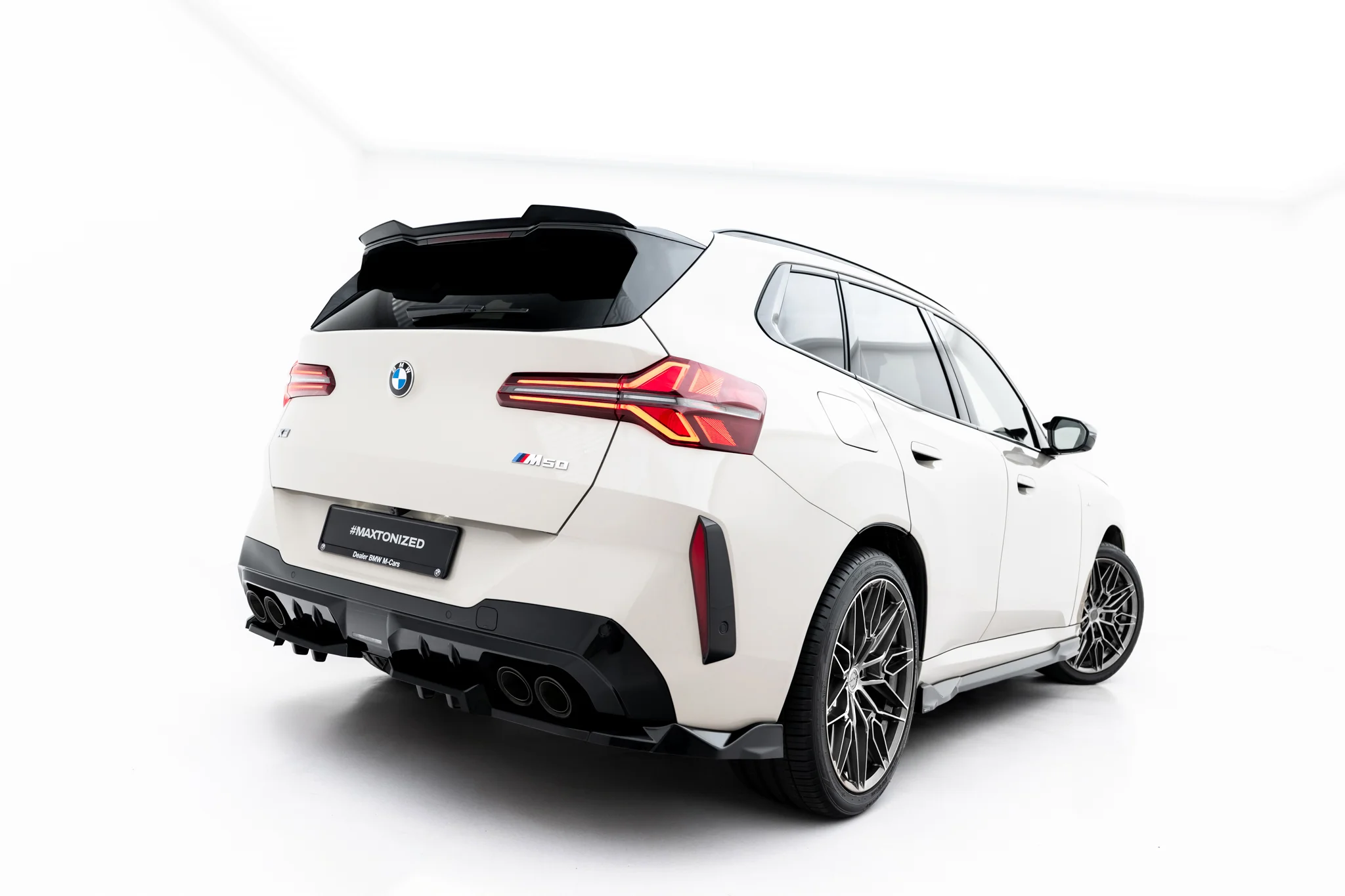 pol_po_Rear-Splitter-with-vertical-bars-BMW-X3-M50-G45-23898_5webp - OPSHOLDERS Rear three-quarter view of a white BMW SUV, showing distinctive taillights and large alloy wheels.