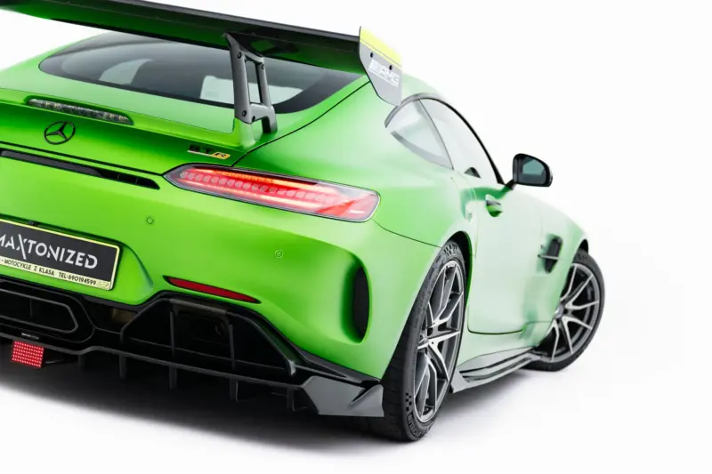 Rear three-quarter view of a bright green Mercedes-AMG GT R with a large rear wing and diffuser.