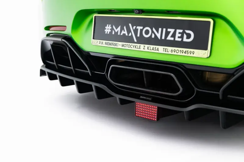 Close-up of a bright green motorcycle rear with a black plate reading '#MAXTONIZED'.