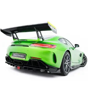 Rear three-quarter view of a bright green sports car with a large black rear wing and diffuser details as seen from the back left side