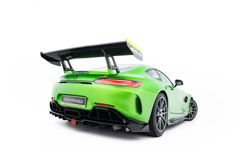 Rear three-quarter view of a bright green sports car with a large black rear wing and diffuser details as seen from the back left side