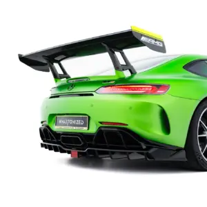 Bright green Mercedes-AMG sports car rear quarter with large black rear wing and visible taillights, close-up shot