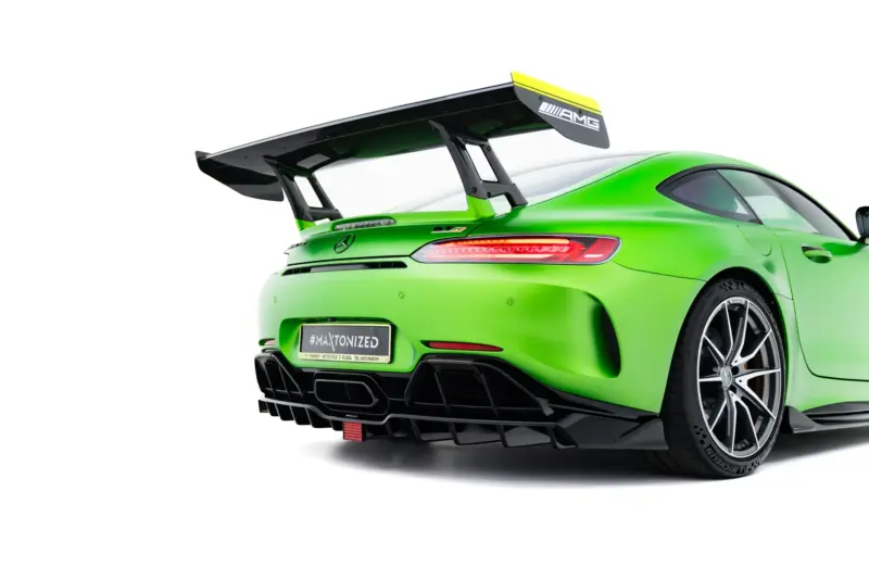 Bright green Mercedes-AMG sports car rear quarter with large black rear wing and visible taillights, close-up shot