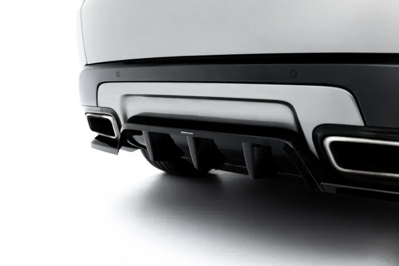 Close-up of a car's rear bumper and dual exhaust pipes with a sleek, dark trim area beneath the trunk lid.