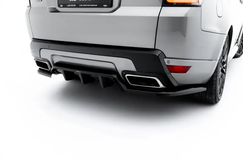 Rear view of a silver SUV showcasing the bumper, dual exhausts, and right taillight with tire visible on the side.