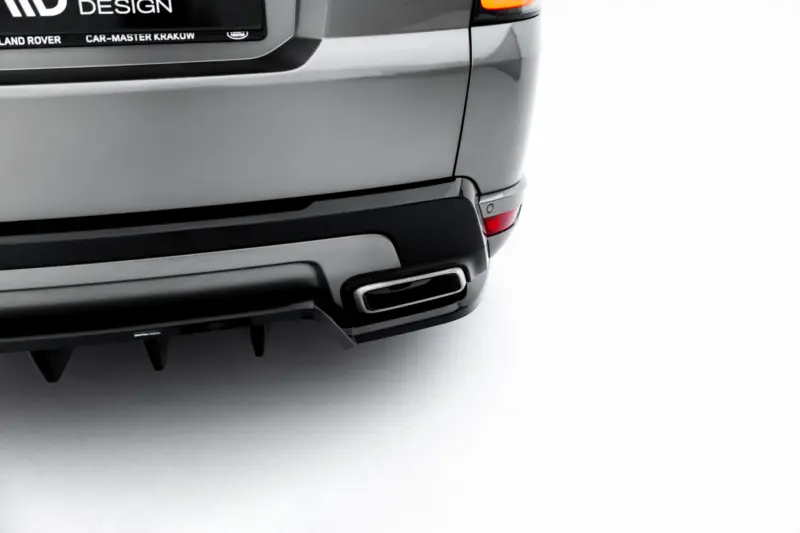 Rear close-up of a gray SUV showing taillight, bumper, and a rear plate area with 'DESIGN' branding and small text along the bottom edge.