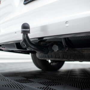 Close-up of a car's rear hitch with a black protective cap reading STEINHOF beneath the bumper