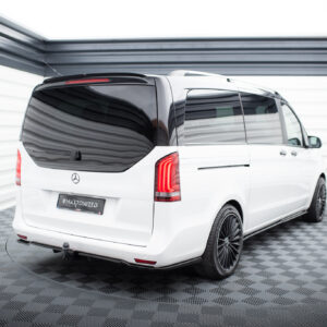 Rear three-quarter view of a white Mercedes-Benz van with dark-tinted windows in a showroom.