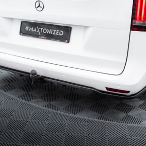 Rear view of a white Mercedes van with a black license plate reading #MAXTONIZED on a checkered showroom floor.