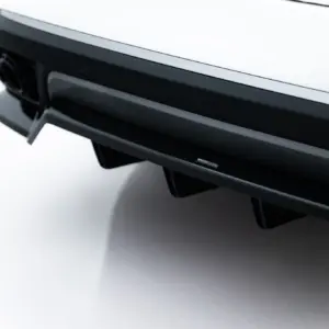 Close-up of a glossy black car spoiler with chrome edge trim and a small Maxton Design badge.