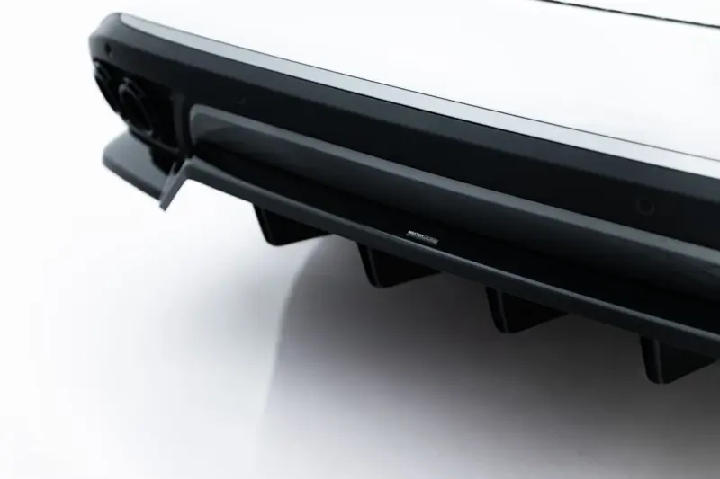 Close-up of a glossy black car spoiler with chrome edge trim and a small Maxton Design badge.