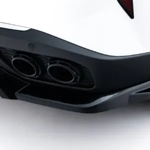 Close-up of a white car's rear bumper showing dual exhausts and black diffuser edges?