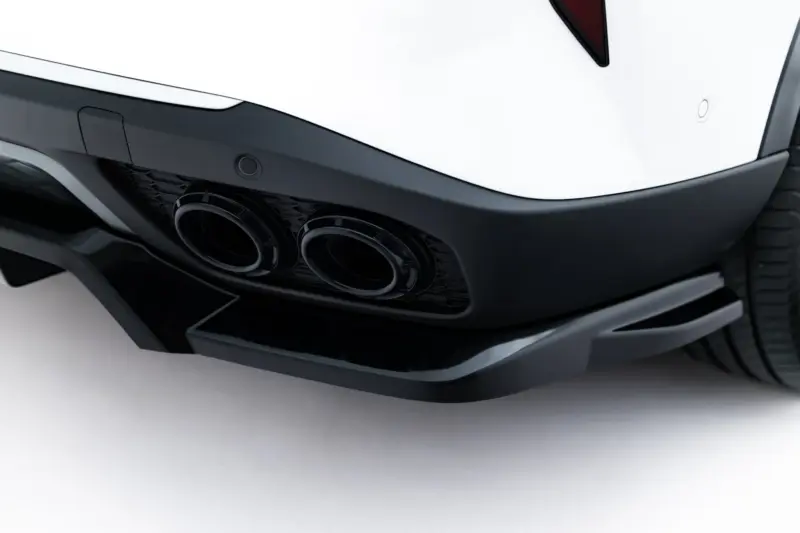Close-up of a white car's rear bumper showing dual exhausts and black diffuser edges?