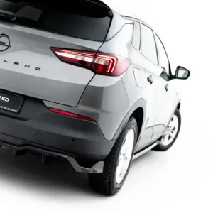 Rear three-quarter view of a silver Opel Grandland SUV, showing the brand badge and taillight details against a white background.