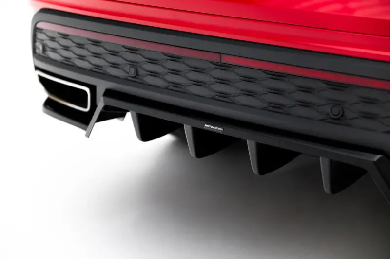 Close-up of the red car's front bumper with a black honeycomb grille and a Maxton Design badge.