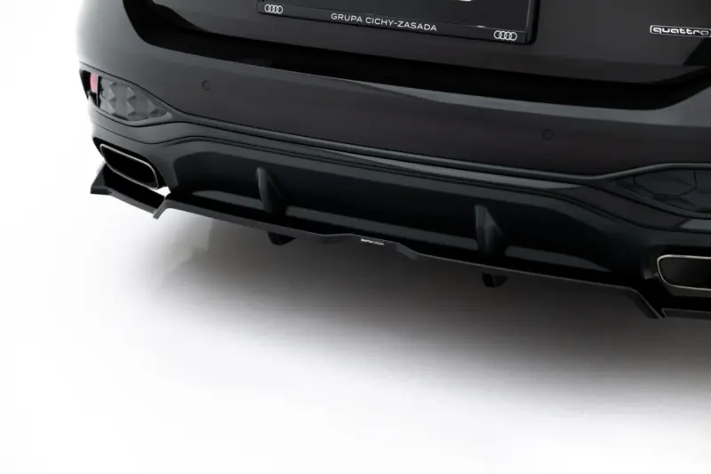 Rear of a black Audi showing quad exhaust tips, sculpted diffuser, and the quattro badge on the tail.