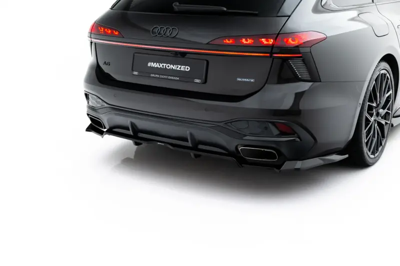 Rear view of a dark gray Audi A6 with illuminated taillights, showing a license plate that reads #MAXTONIZED and a small Audi logo on the tailgate.