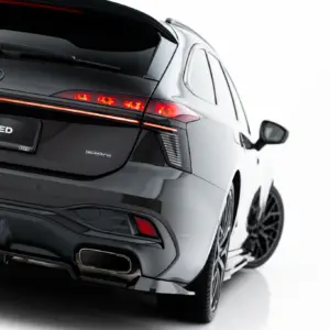 Rear view of a black Audi SUV showing red taillights, Audi rings, and a #MAXTONIZED plate with quattro badge visible on the tailgate