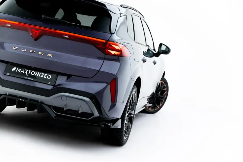 pol_po_Rear-Splitter-with-vertical-bars-V-3-Cupra-Terramar-Mk1-Version-with-towbar-23819_7webp - OPSHOLDERS Rear three-quarter view of a dark blue Cupra SUV, showing illuminated red tail lights, the Cupra badge, and a license plate reading #MAXTONIZED