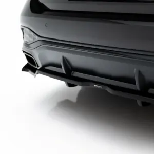 Close-up of a dark gray car's rear bumper with a sculpted diffuser and a single exhaust, isolated on white background.