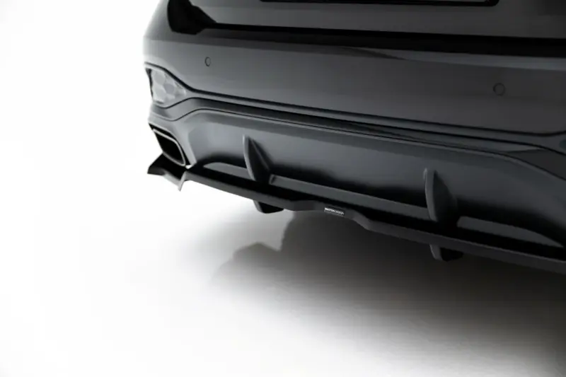 pol_po_Rear-Splitter-with-vertical-bars-V-4-Audi-A6-S-Line-C9-24007_1webp - OPSHOLDERS Close-up of a dark gray car's rear bumper with a sculpted diffuser and a single exhaust, isolated on white background.