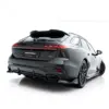 pol_po_Rear-Splitter-with-vertical-bars-V-4-Audi-A6-S-Line-C9-24007_4webp - OPSHOLDERS Rear three-quarter view of a dark Audi with illuminated tail lights, photographed against a white studio background.
