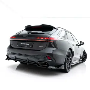 Rear three-quarter view of a dark Audi with illuminated tail lights, photographed against a white studio background.