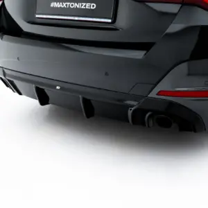 Rear view of a dark car showing taillights and a license plate with the hashtag '#MAXTONIZED'.