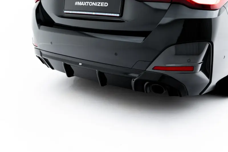 Rear view of a dark car showing taillights and a license plate with the hashtag '#MAXTONIZED'.