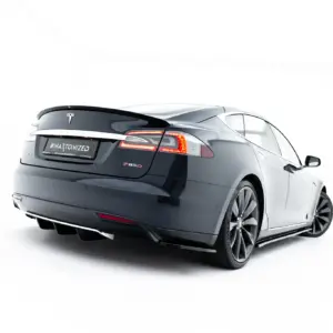 Rear three-quarter view of a dark gray Tesla Model S P85D, showing the taillights and the '#MAYTONIZED' plate on a white backdrop.