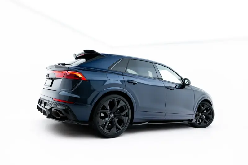 pol_po_Set-of-Prepreg-Carbon-Fiber-Splitters-Audi-RSQ8-Mk1-Facelift-23818_10webp - OPSHOLDERS Blue luxury SUV shown from a rear-side angle with prominent taillights and large black alloy wheels in a studio setting.