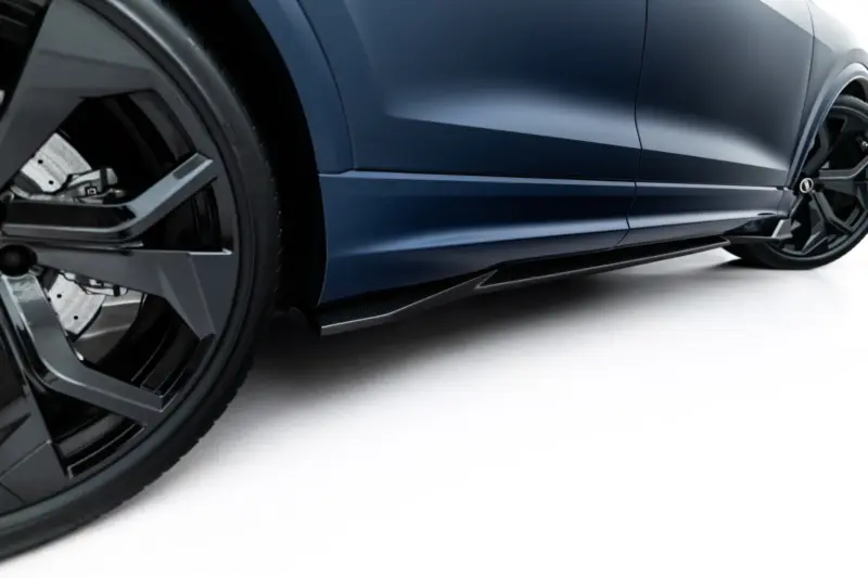 pol_po_Set-of-Prepreg-Carbon-Fiber-Splitters-Audi-RSQ8-Mk1-Facelift-23818_12webp - OPSHOLDERS Close-up of a dark blue car's side panel and front wheel, showing sleek body lines and a low side skirt.
