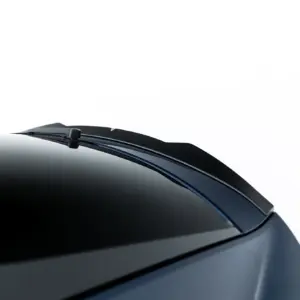 Close-up of a car windshield with a parked wiper resting along the lower edge of the glass against a white background