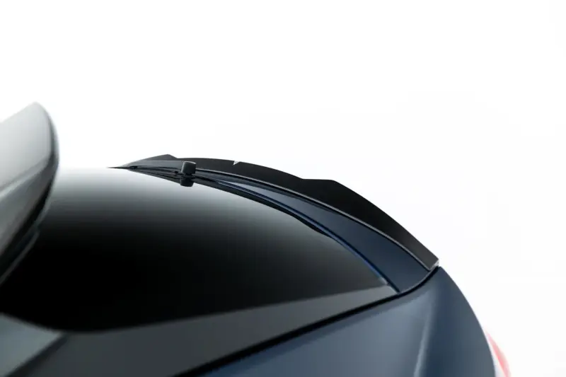 pol_po_Set-of-Prepreg-Carbon-Fiber-Splitters-Audi-RSQ8-Mk1-Facelift-23818_13webp - OPSHOLDERS Close-up of a car windshield with a parked wiper resting along the lower edge of the glass against a white background