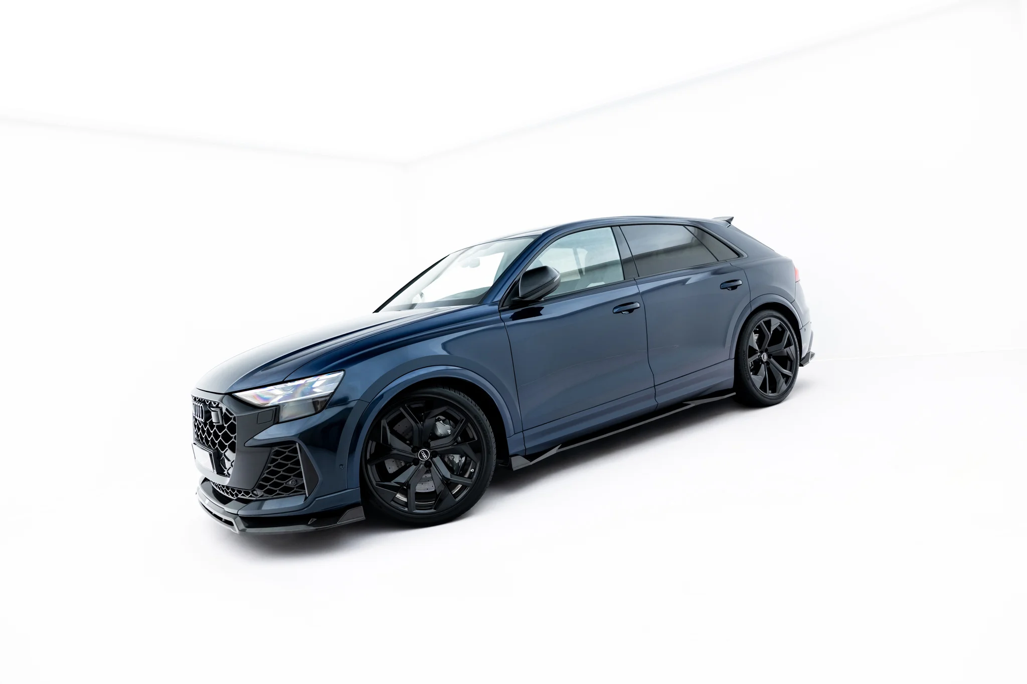 pol_po_Set-of-Prepreg-Carbon-Fiber-Splitters-Audi-RSQ8-Mk1-Facelift-23818_17webp - OPSHOLDERS Blue luxury SUV photographed in a bright white studio, angled to show the front and side profile with large black wheels.