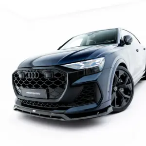 Front three-quarter view of a blue Audi SUV with a honeycomb grille in a bright studio setting