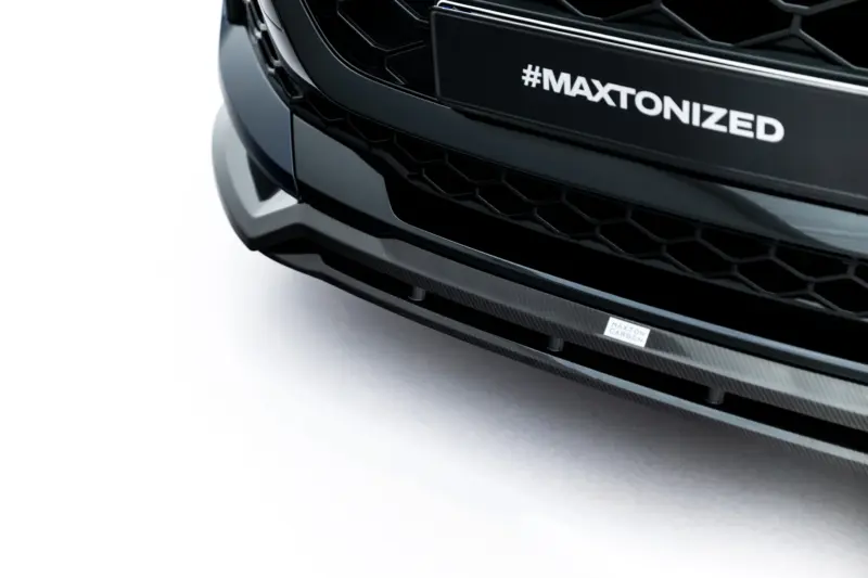 pol_po_Set-of-Prepreg-Carbon-Fiber-Splitters-Audi-RSQ8-Mk1-Facelift-23818_21webp - OPSHOLDERS Close-up of a black car front with a hex grille and a carbon fiber lip, featuring the hashtag '#MAXTONIZED' on the bumper plate