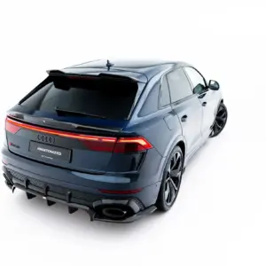 Rear three-quarter view of a silver SUV with taillights lit, on a white studio background, emphasizing sleek design and roof spoiler.