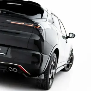 Rear three-quarter view of a black luxury SUV with illuminated orange taillights and dual exhausts