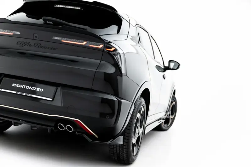 Rear three-quarter view of a black luxury SUV with illuminated orange taillights and dual exhausts