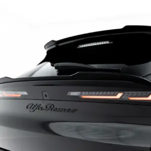 Rear view of a sleek black Alfa Romeo car with glowing red taillights and visible logo on the trunk.