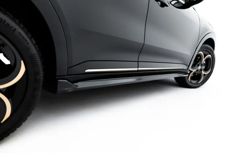 Close-up of a gray car's side panel, door seam, and wheel with an alloy rim and light-colored accents.