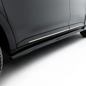 Close-up of a dark gray car showing the side panel, door, and front wheel and tire.