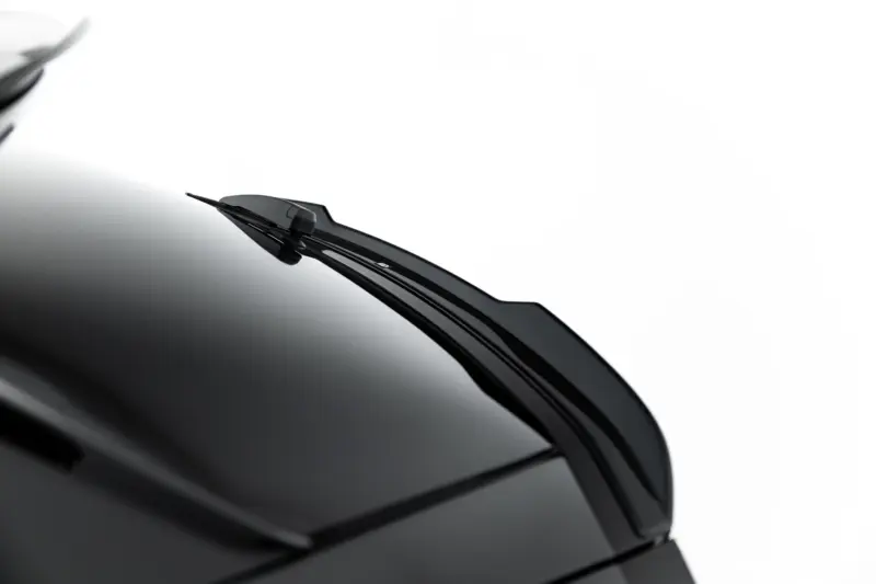 Close-up of a black car's windshield wiper resting on the glossy hood, diagonal across the frame.
