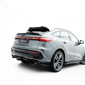 Rear three-quarter view of a silver Audi SUV with a black roof spoiler and red taillights visible at the back, including a license plate reading #MAXTONIZED.